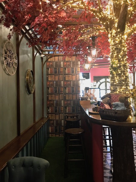 a bar with a shelf and bookshelf with lights