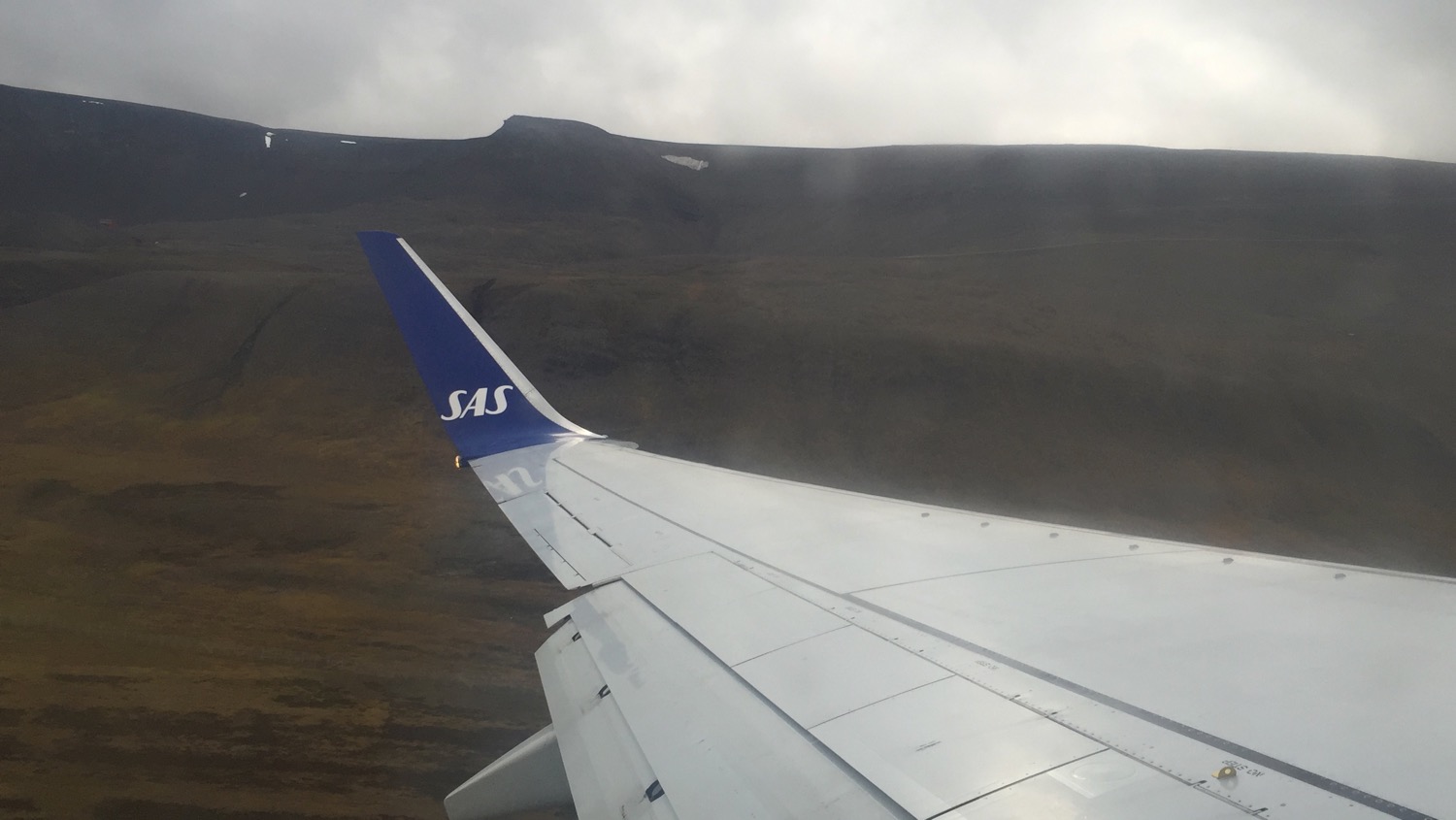 the wing of an airplane over a mountain