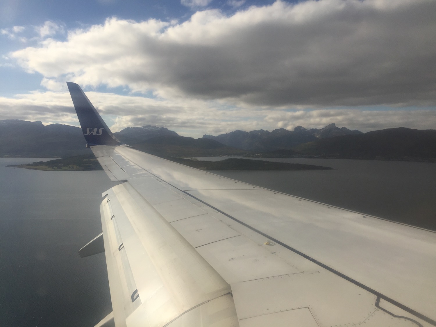 an airplane wing with mountains in the background