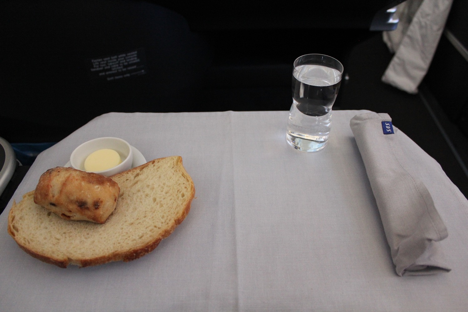 a piece of bread and a glass of water on a table