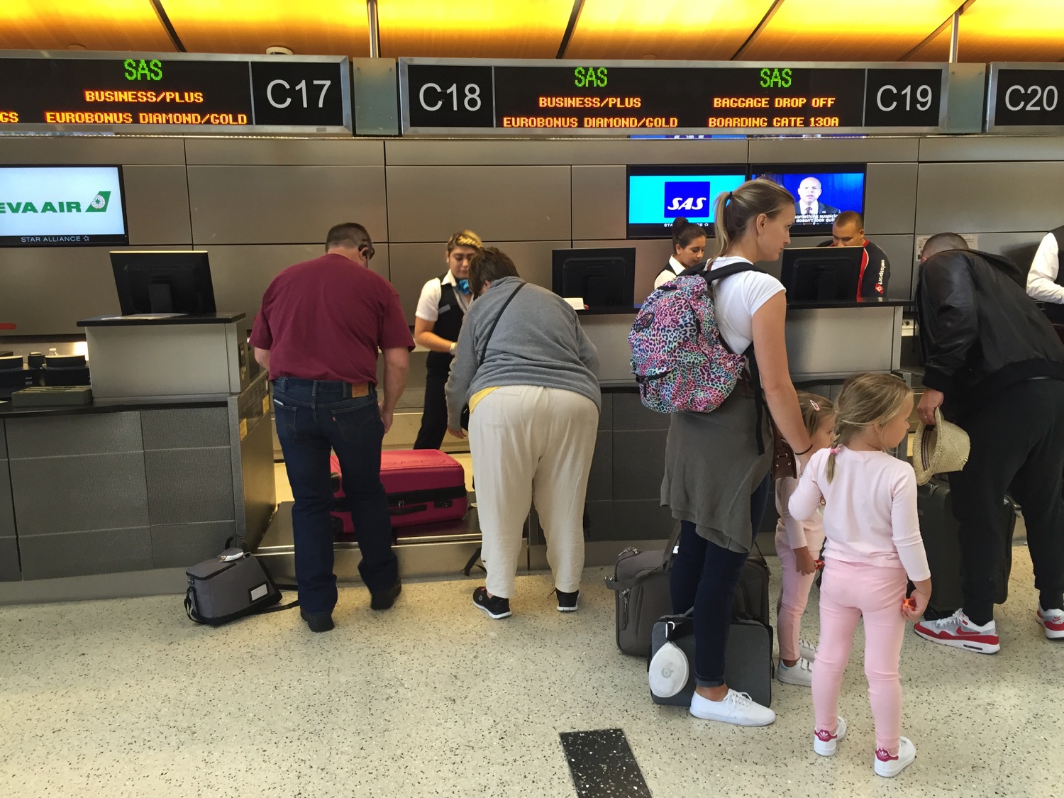 people standing in front of a counter with luggage