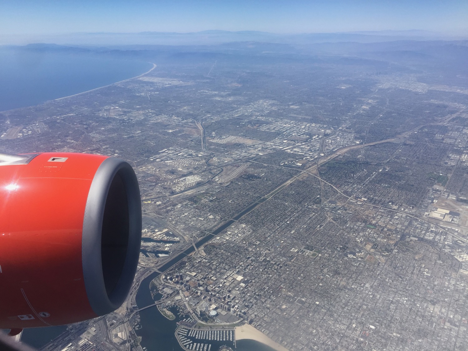 an airplane wing with a city and water