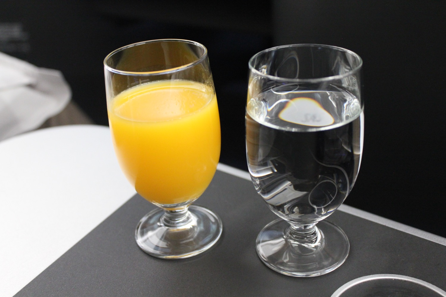 a glass of orange juice and a clear glass of water