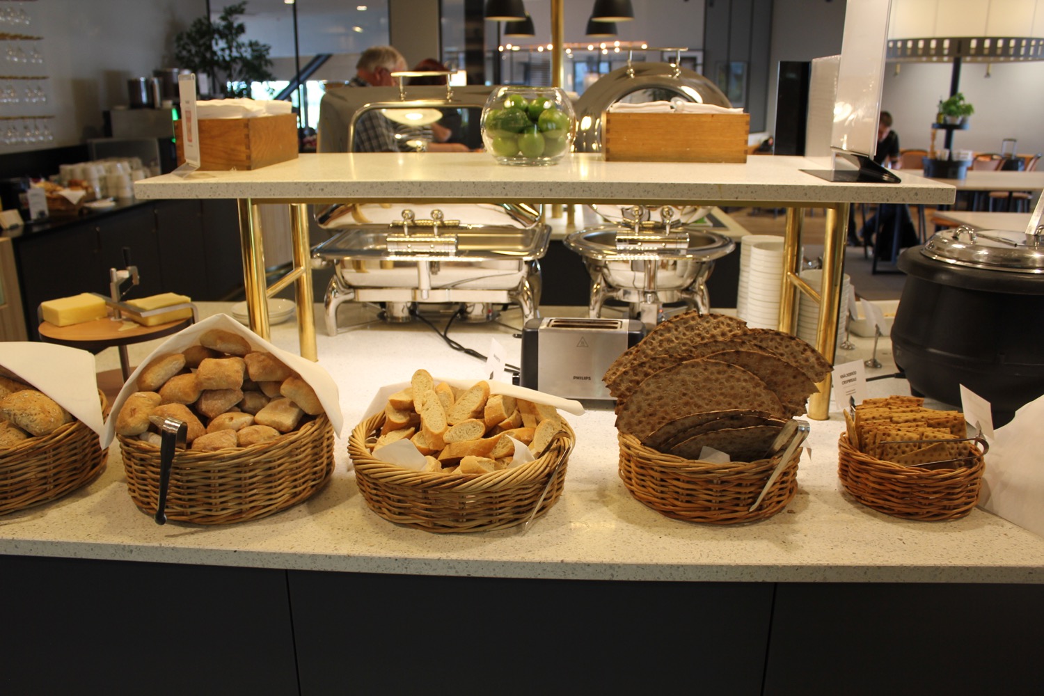 a buffet table with baskets of bread and a variety of food