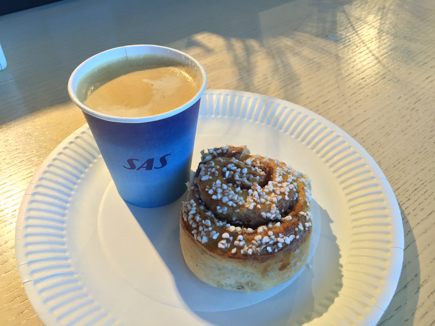 a cinnamon roll and a cup of coffee on a plate