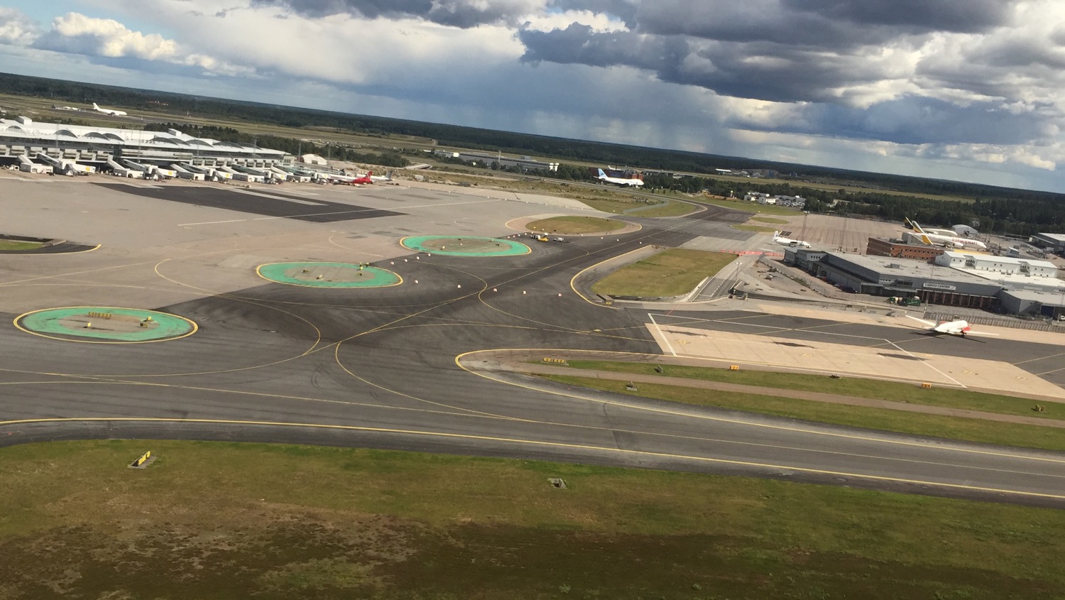 an airport runway with a few planes in the background