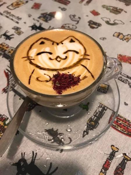 a cup of coffee with a drawing on the foam