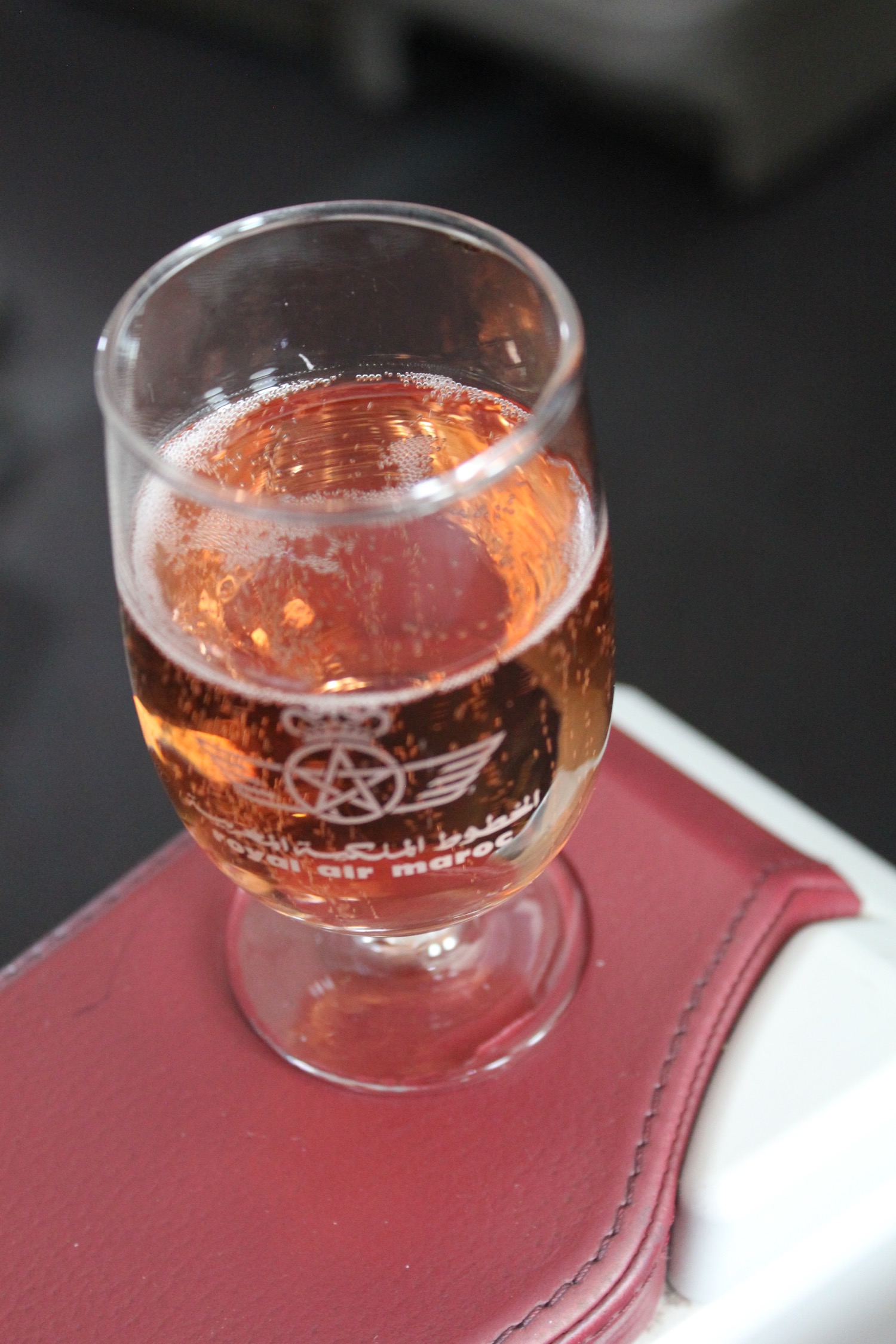 a glass of liquid on a red leather surface
