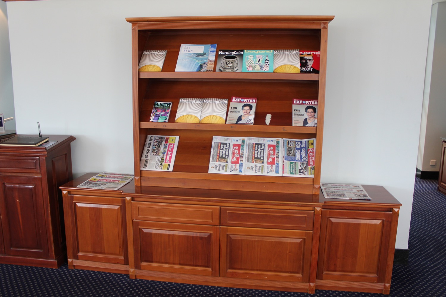 a wooden cabinet with magazines on it