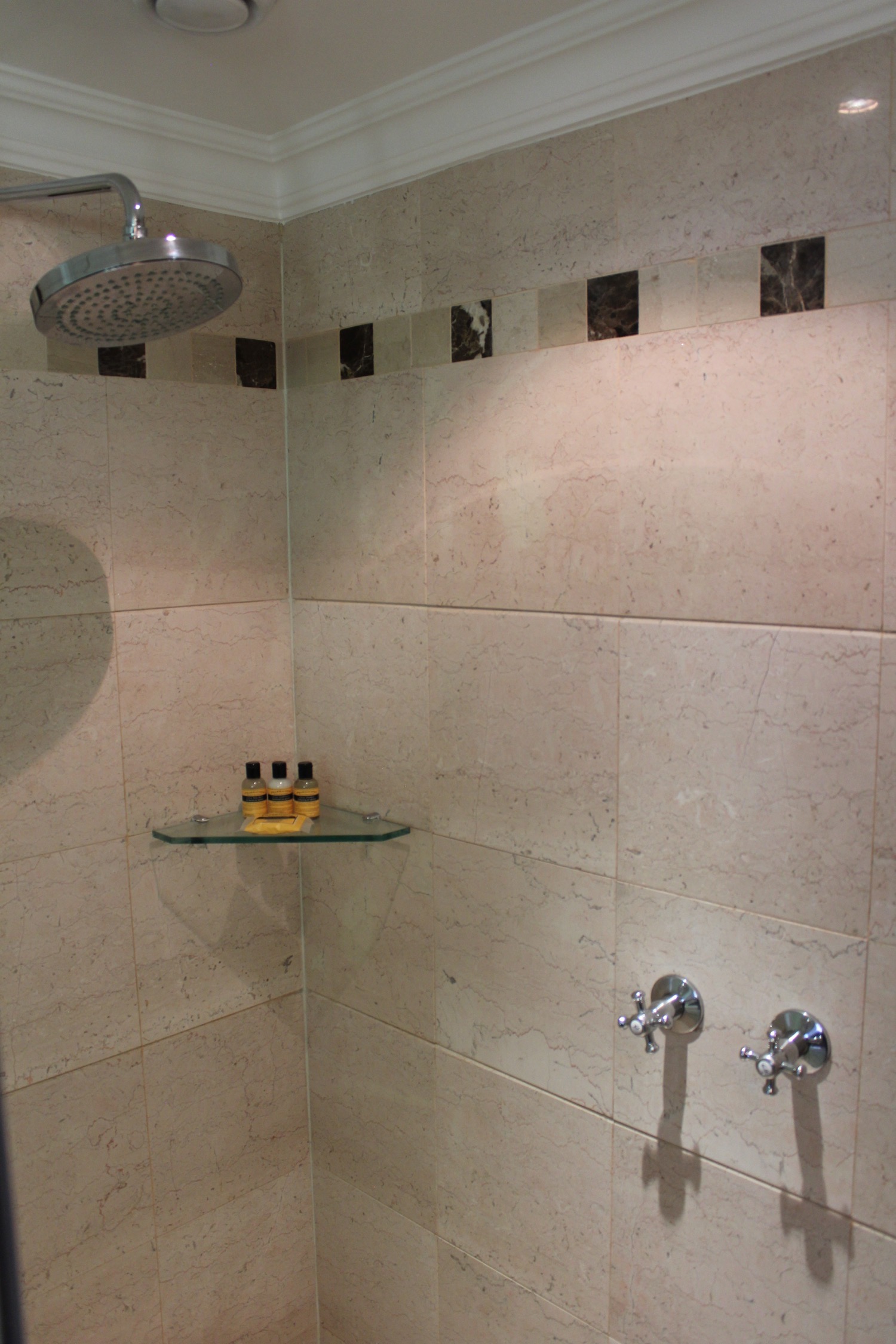 a shower with a shelf and shower head