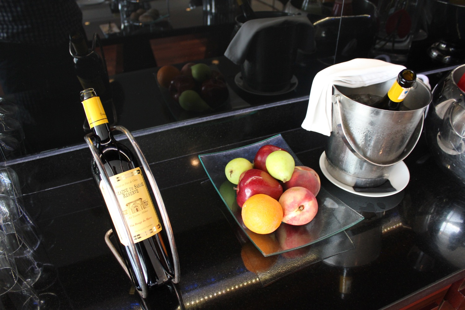 a bottle of wine and fruit on a counter