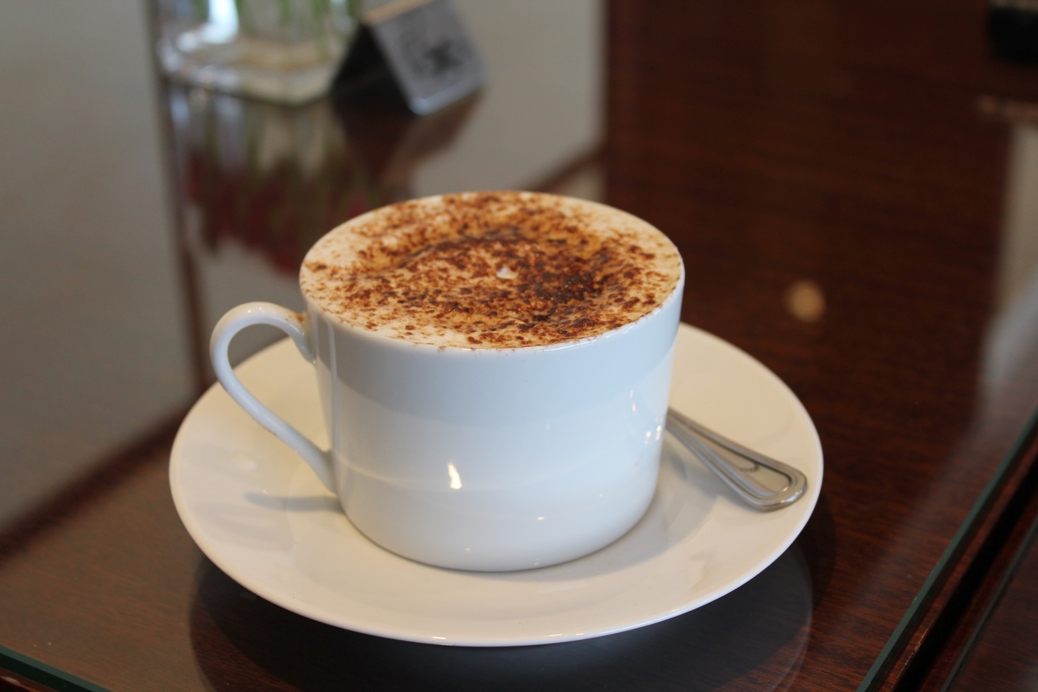 a white cup with brown froth on top of it