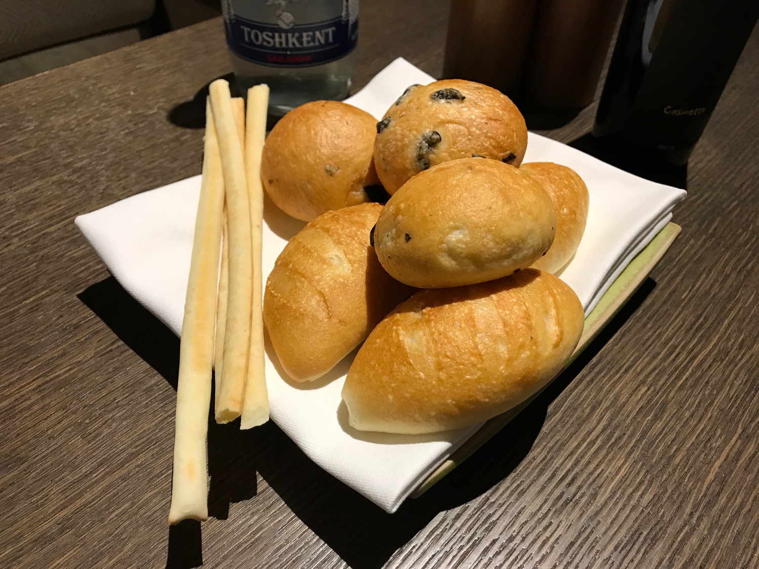 a plate of bread rolls and a bottle of water