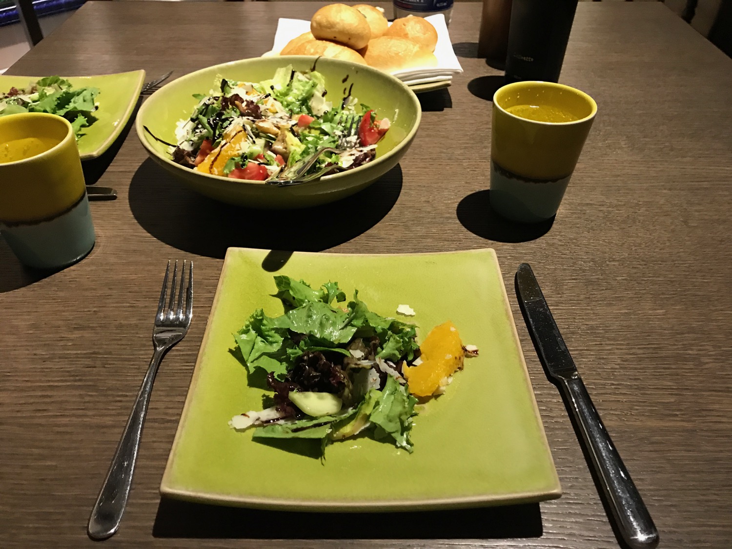 a salad and a cup of juice on a table