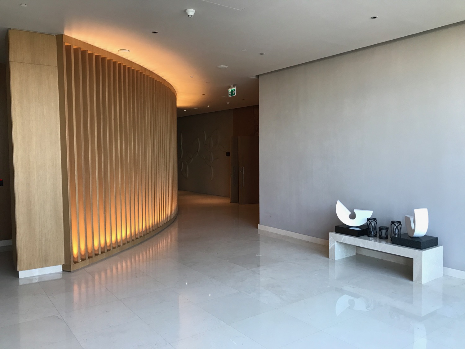 a hallway with a curved wall and a bench