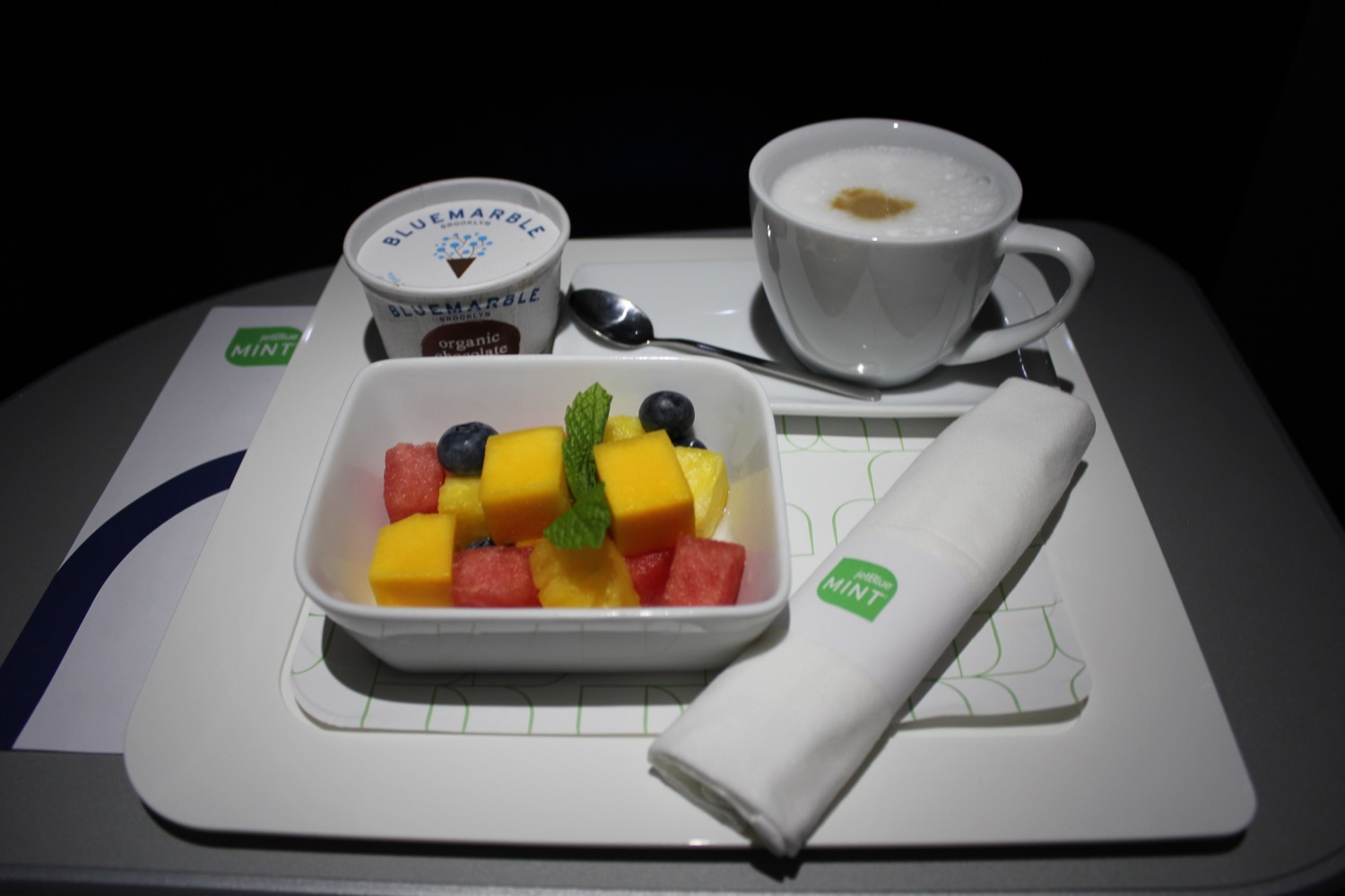 a tray with fruit and a cup of coffee