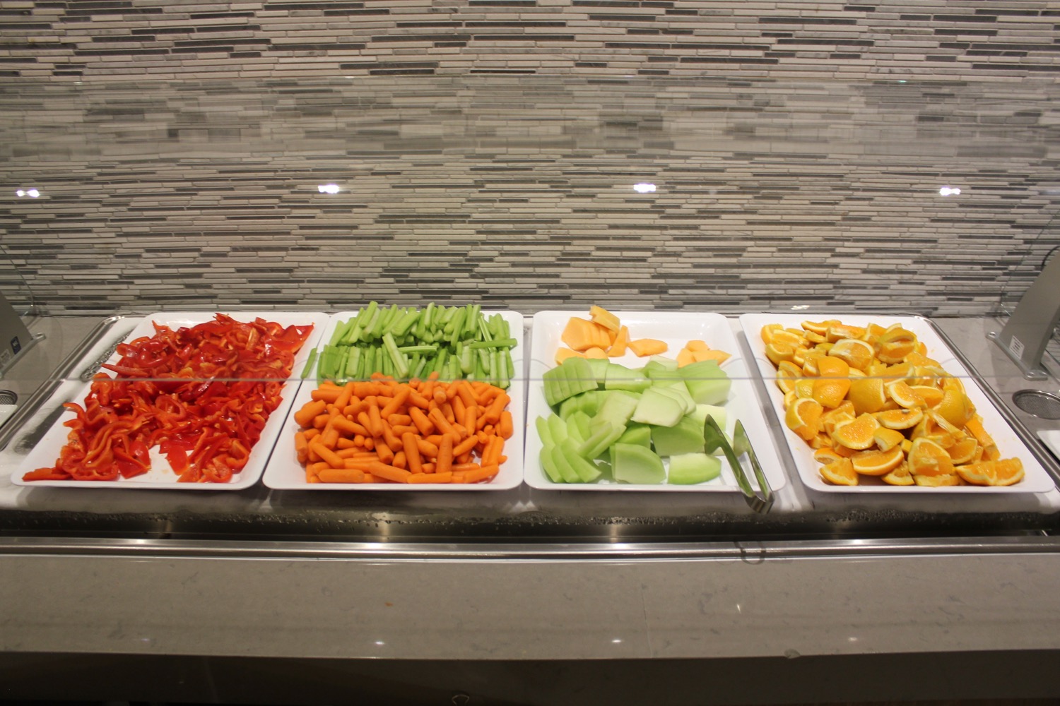 a row of plates of vegetables