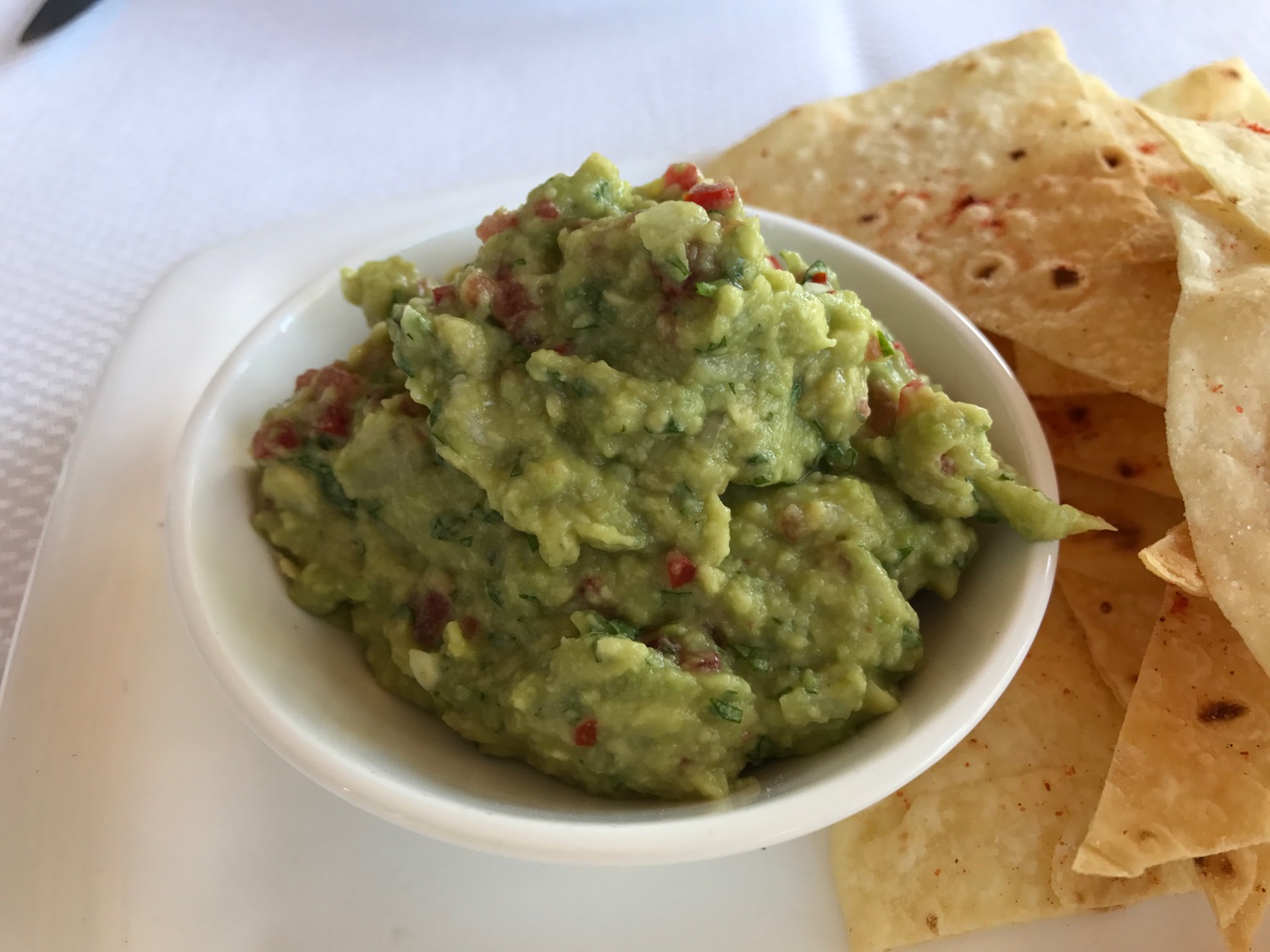 a bowl of guacamole and chips