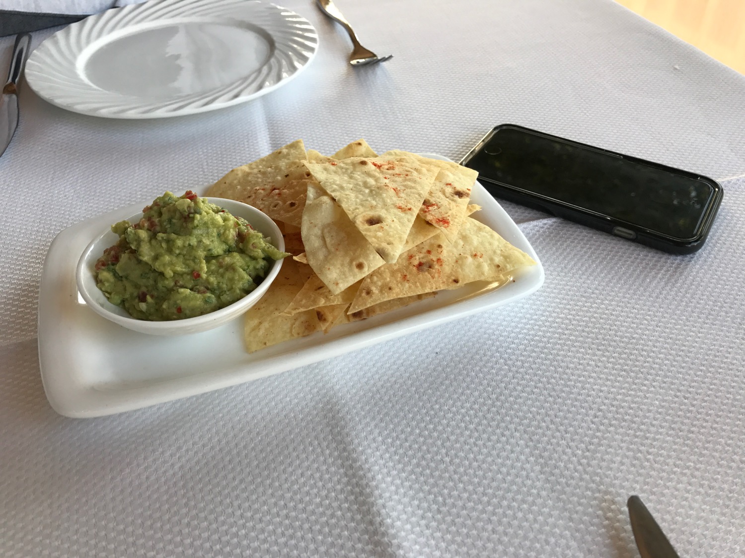 a plate of chips and guacamole on a table