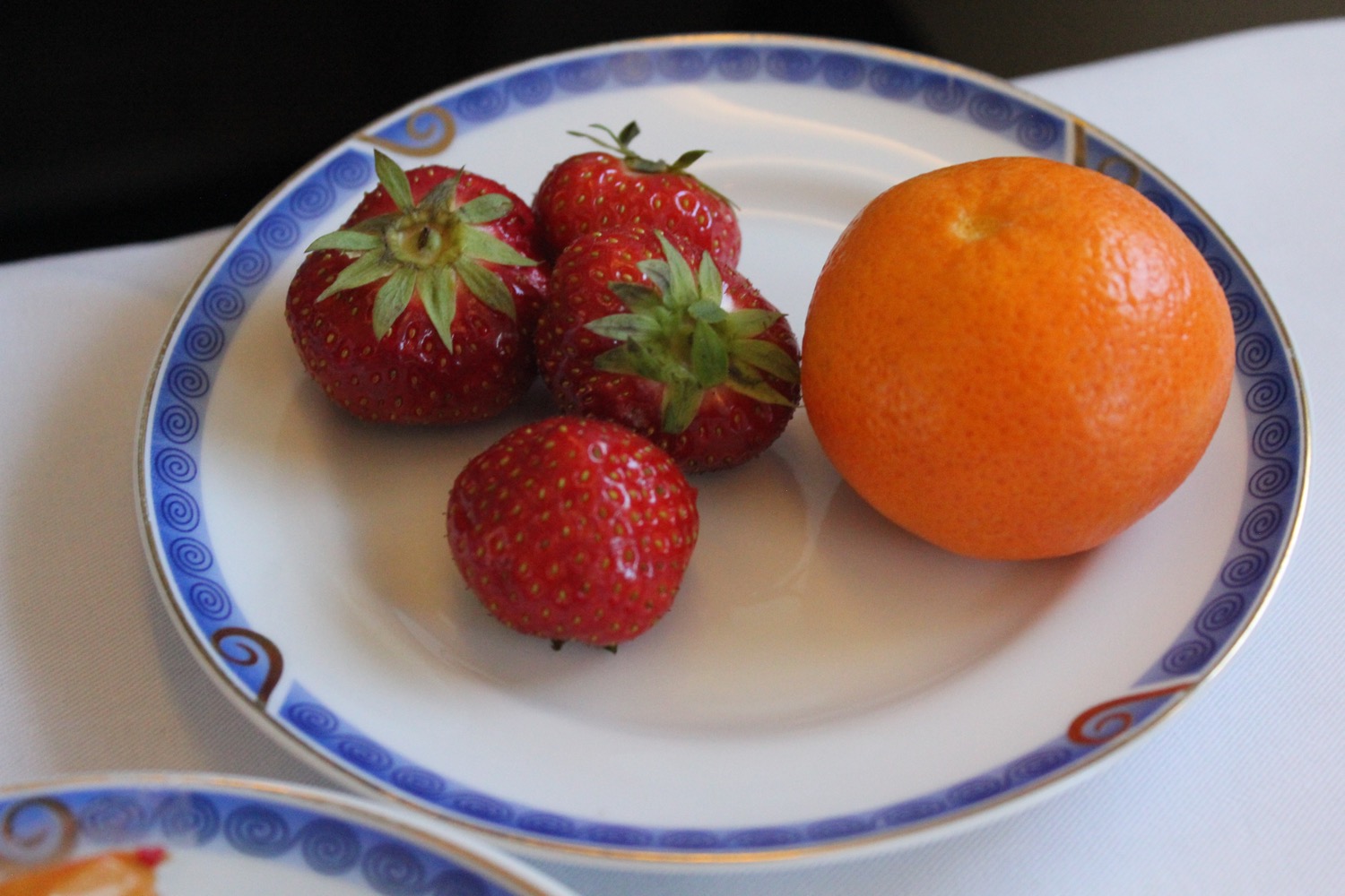 a plate of strawberries and an orange