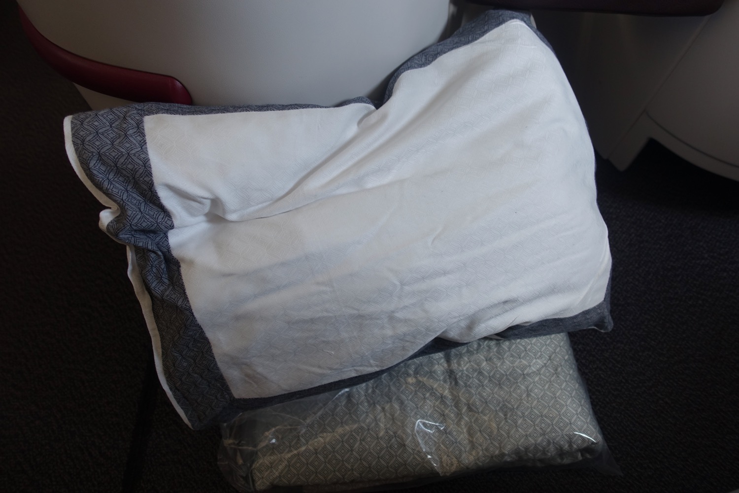 a white and grey pillow on a black surface