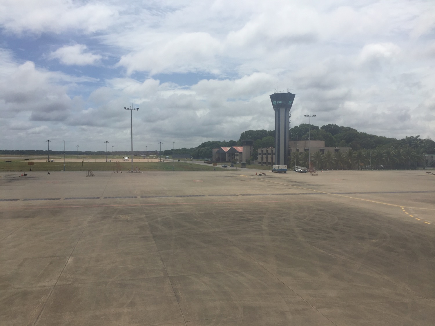 a runway with a tower and trees in the background