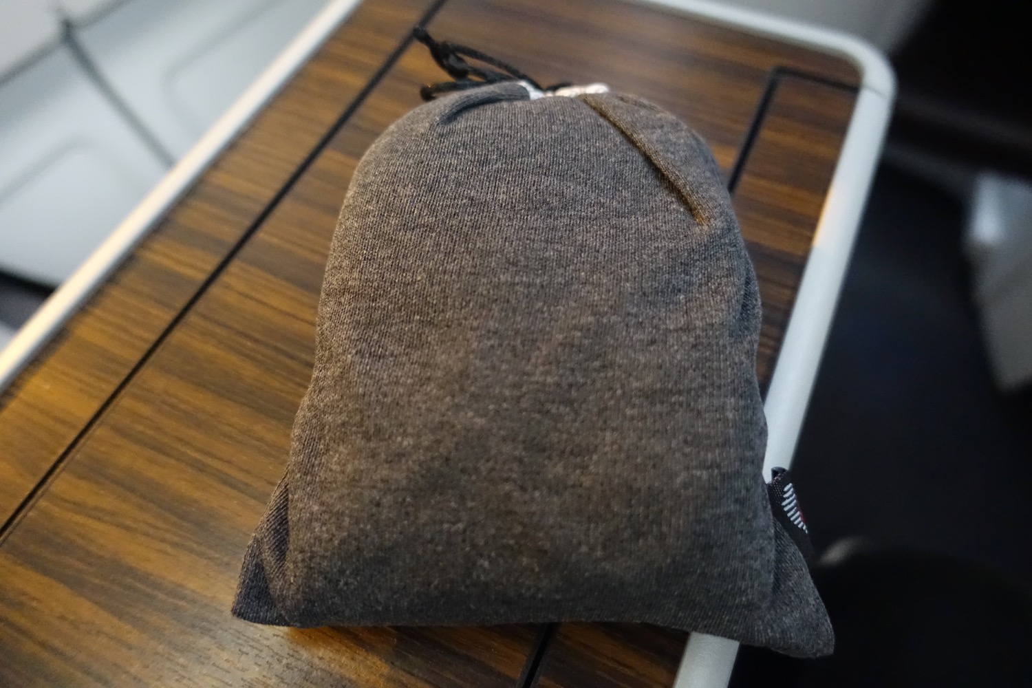 a small grey bag on a wood surface