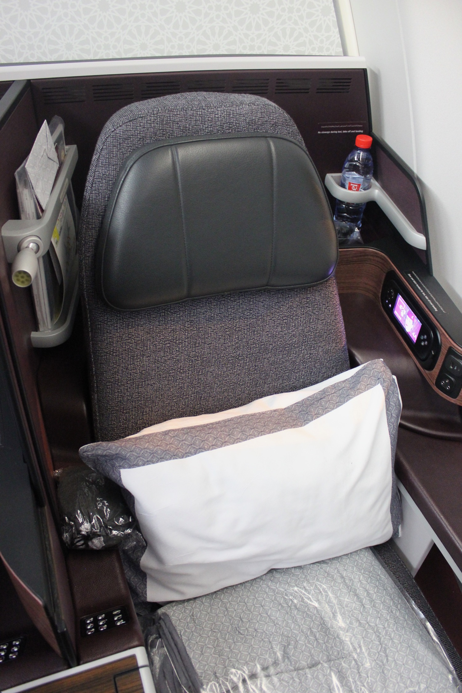 a seat with a pillow and a bottle of water on the side