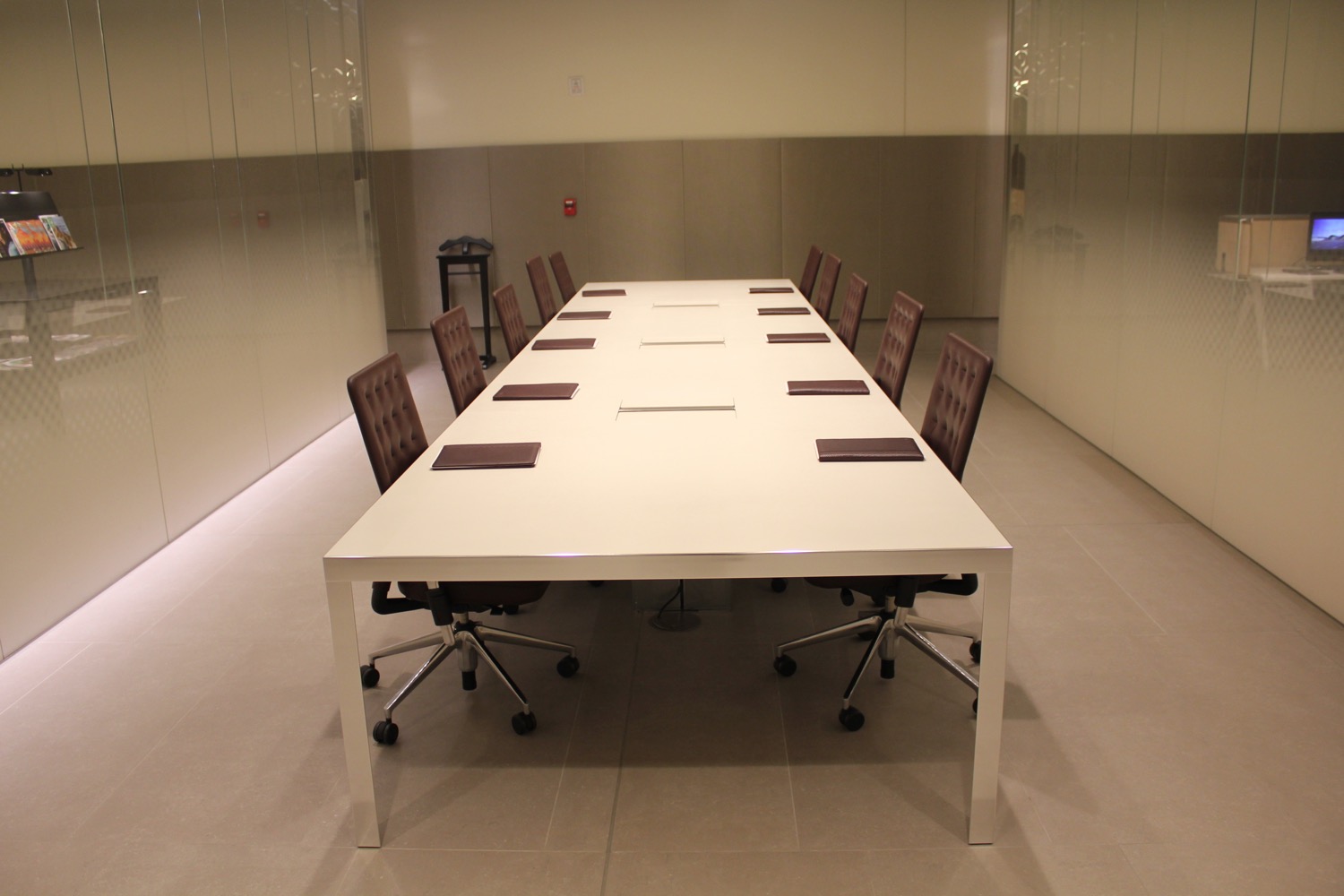 a long white table with brown chairs