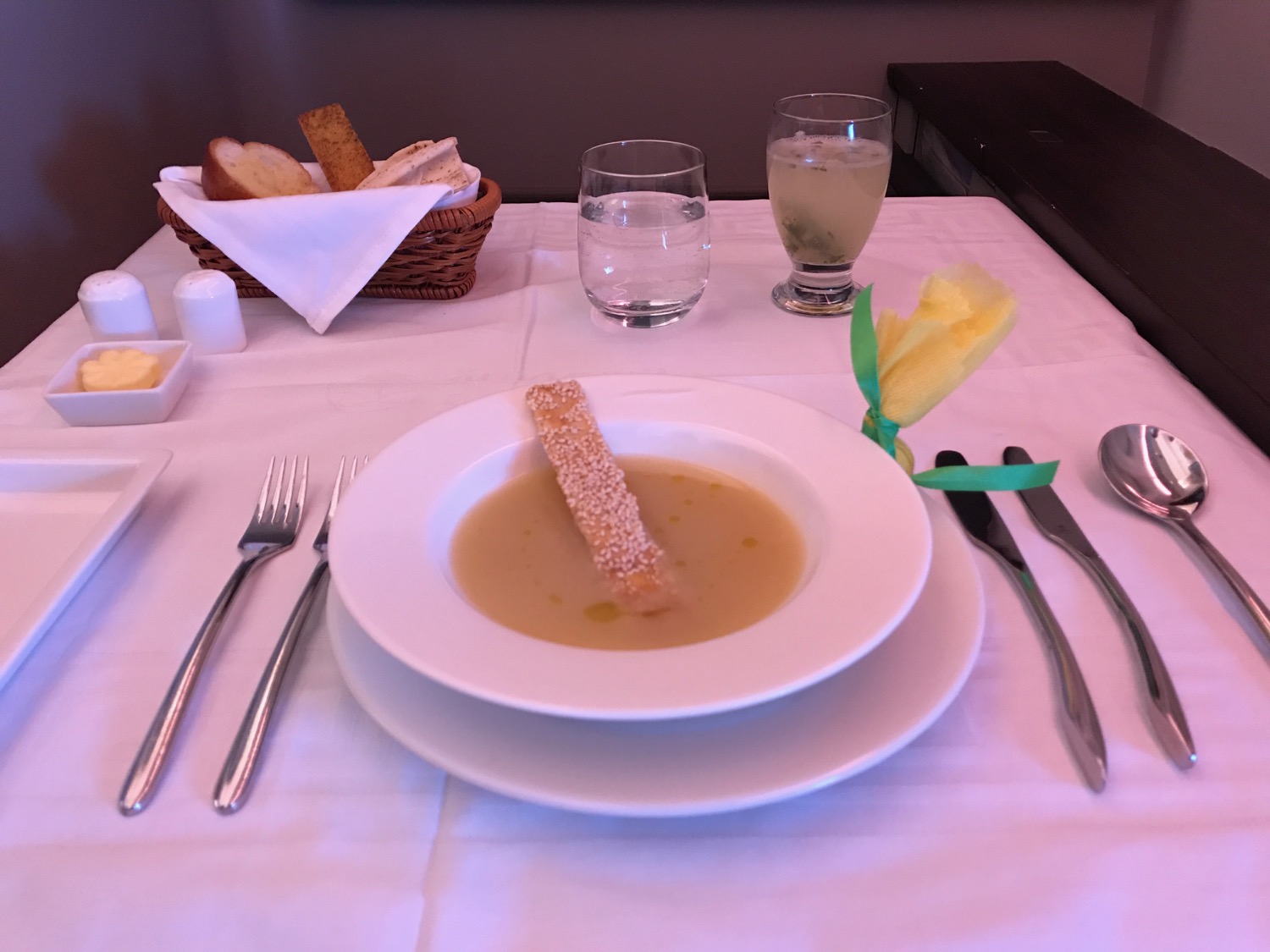 a plate of soup with bread stick on it
