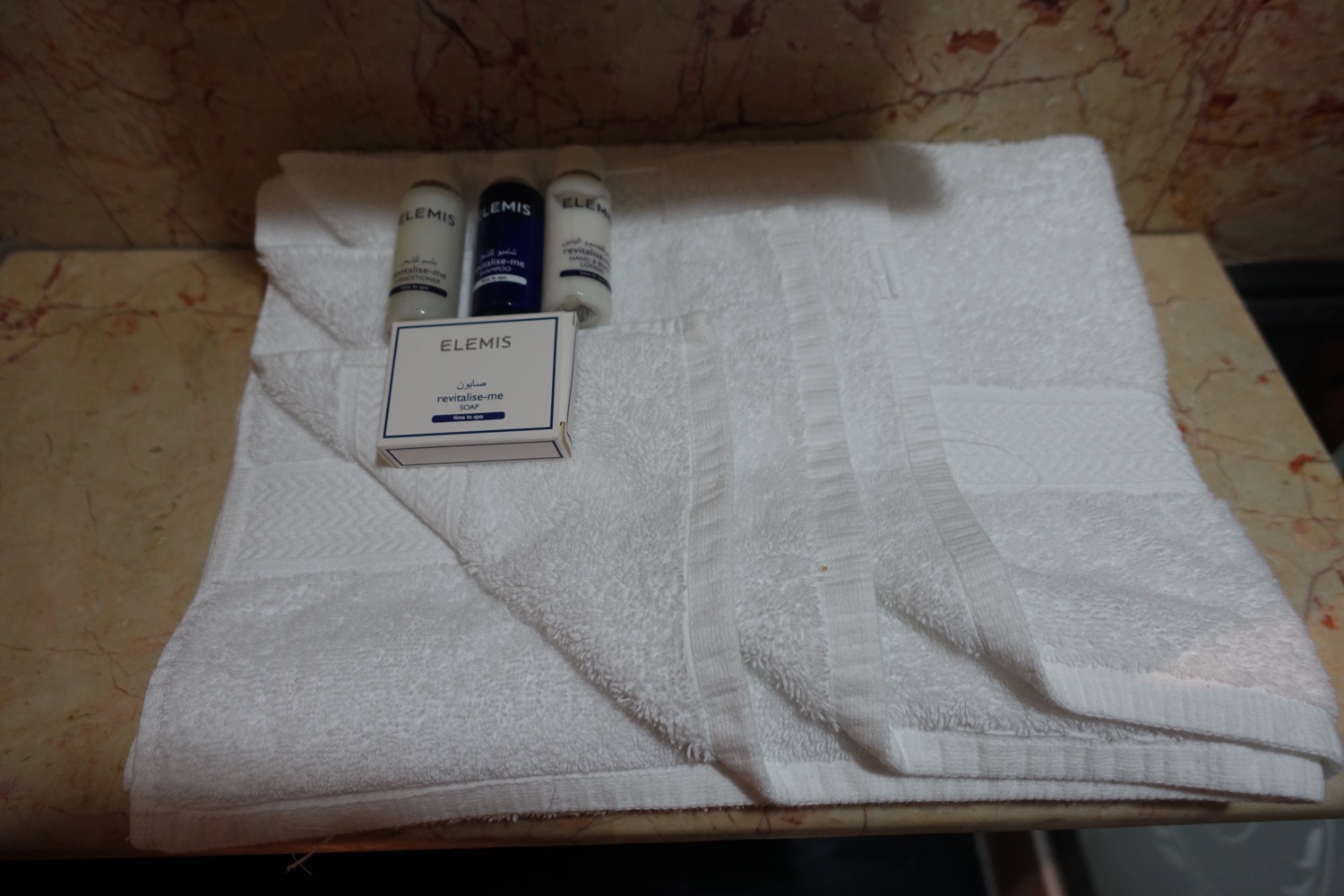 a white towel with a box and bottles of shampoo on it