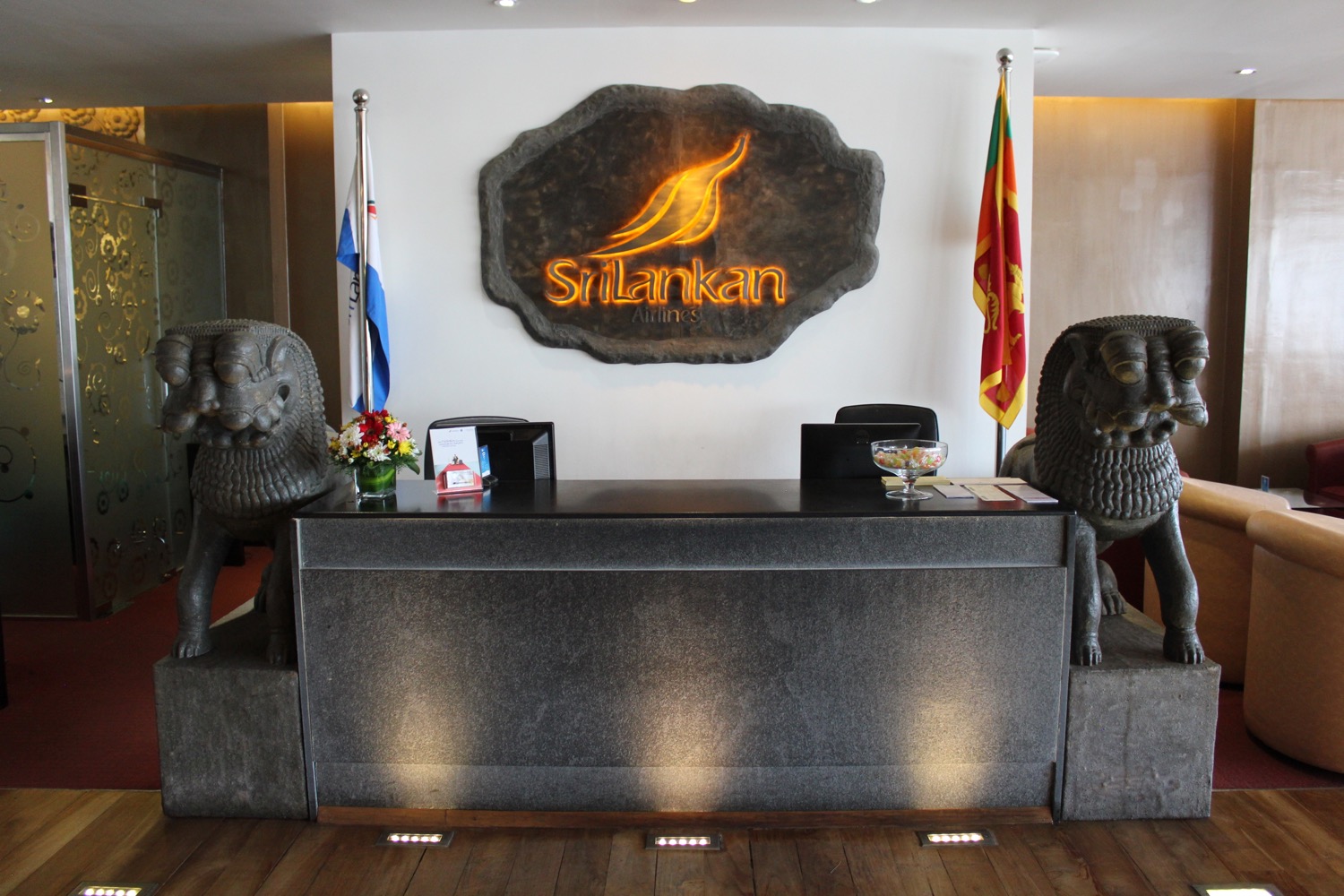 a reception desk with two lions and flags