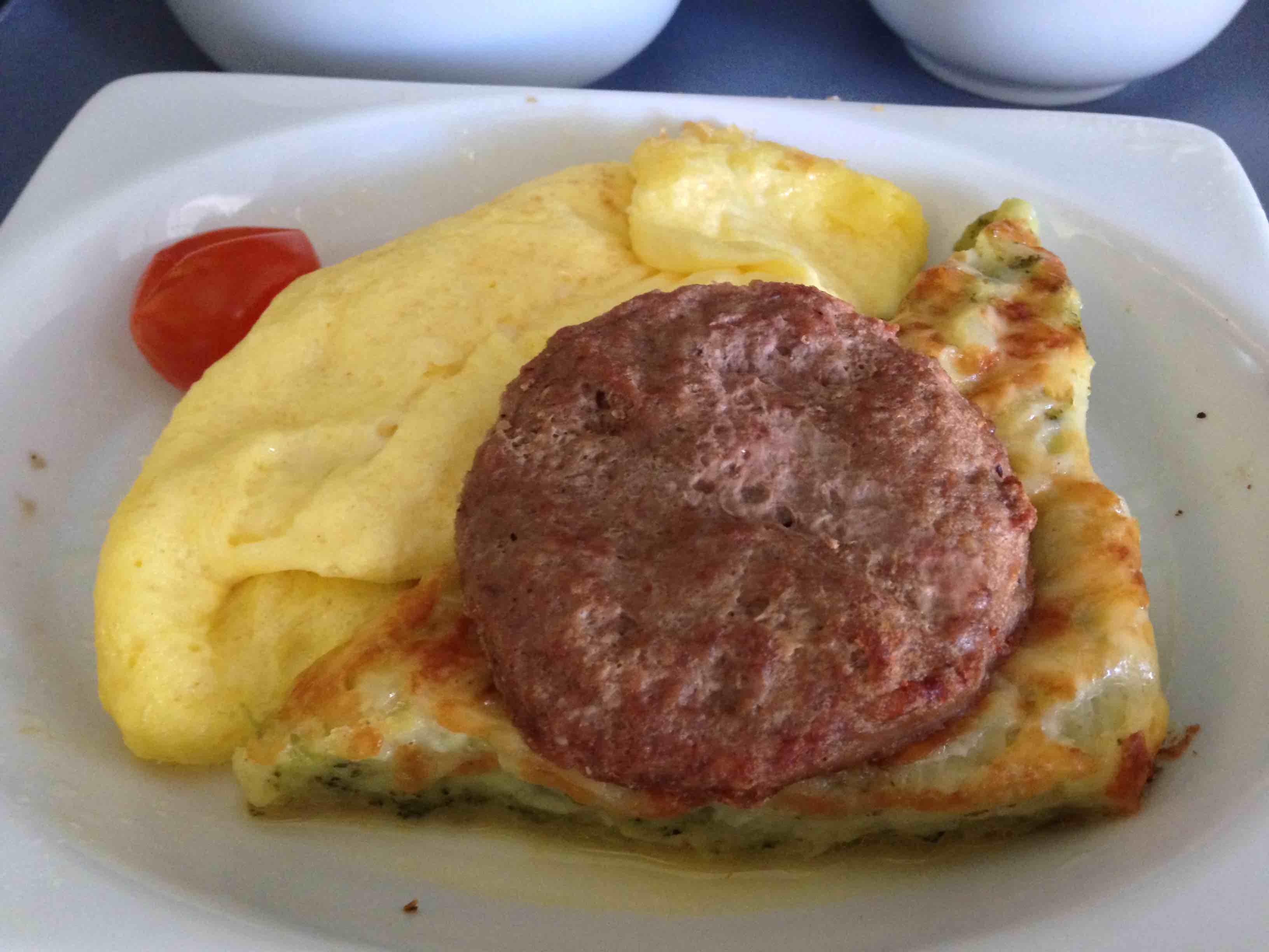 a plate of food with a hamburger and omelette