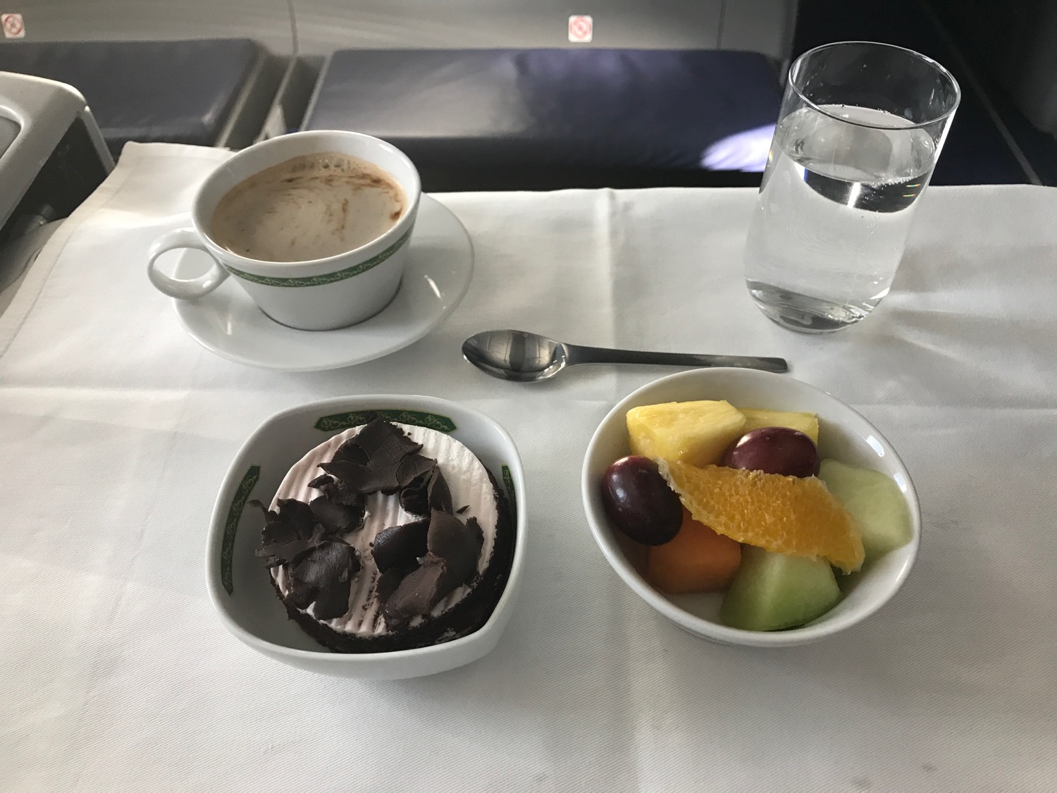 a bowl of fruit and a cup of coffee on a table