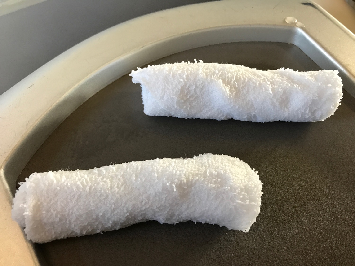 a pair of white rolled up towels