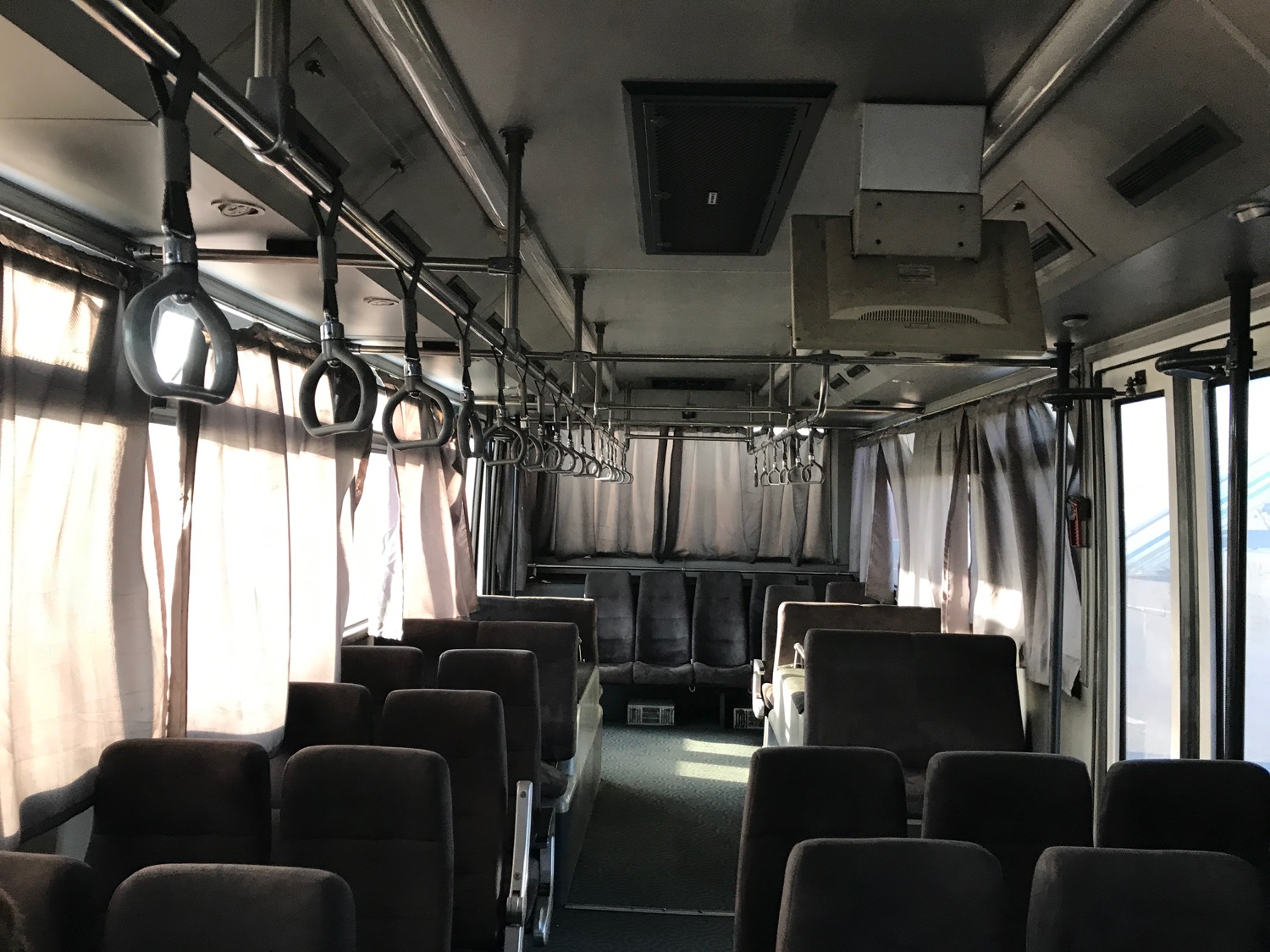 inside a bus with seats and handles