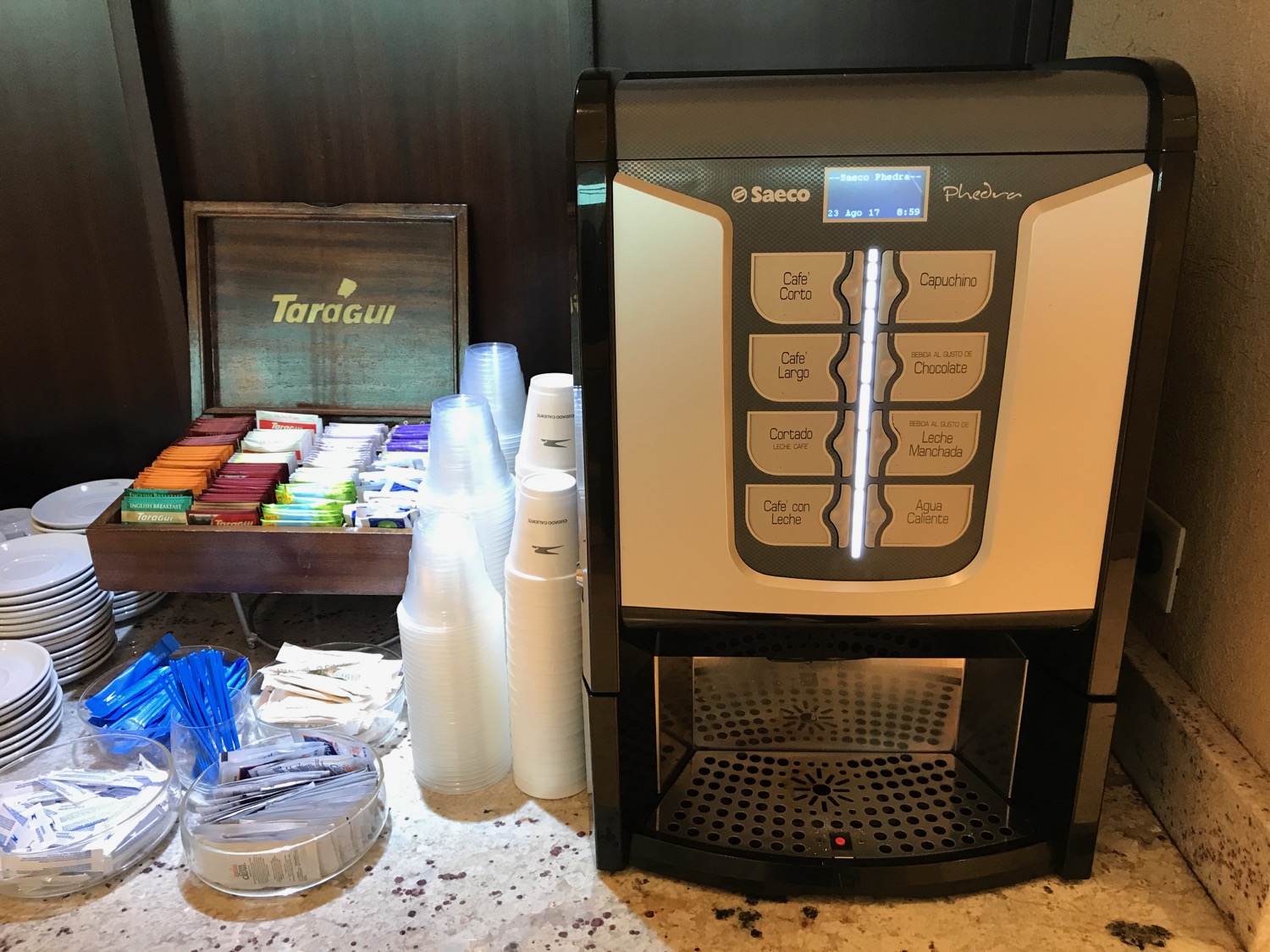 a coffee machine next to cups and other items