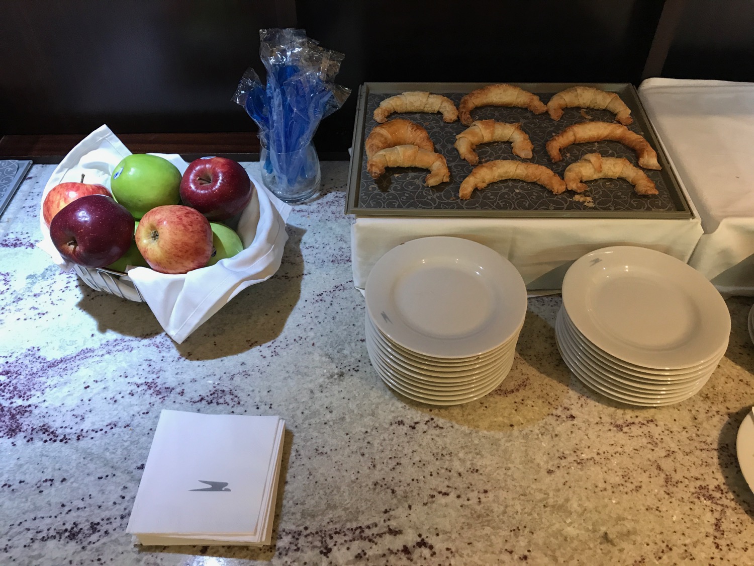 a tray of croissants and apples on a table