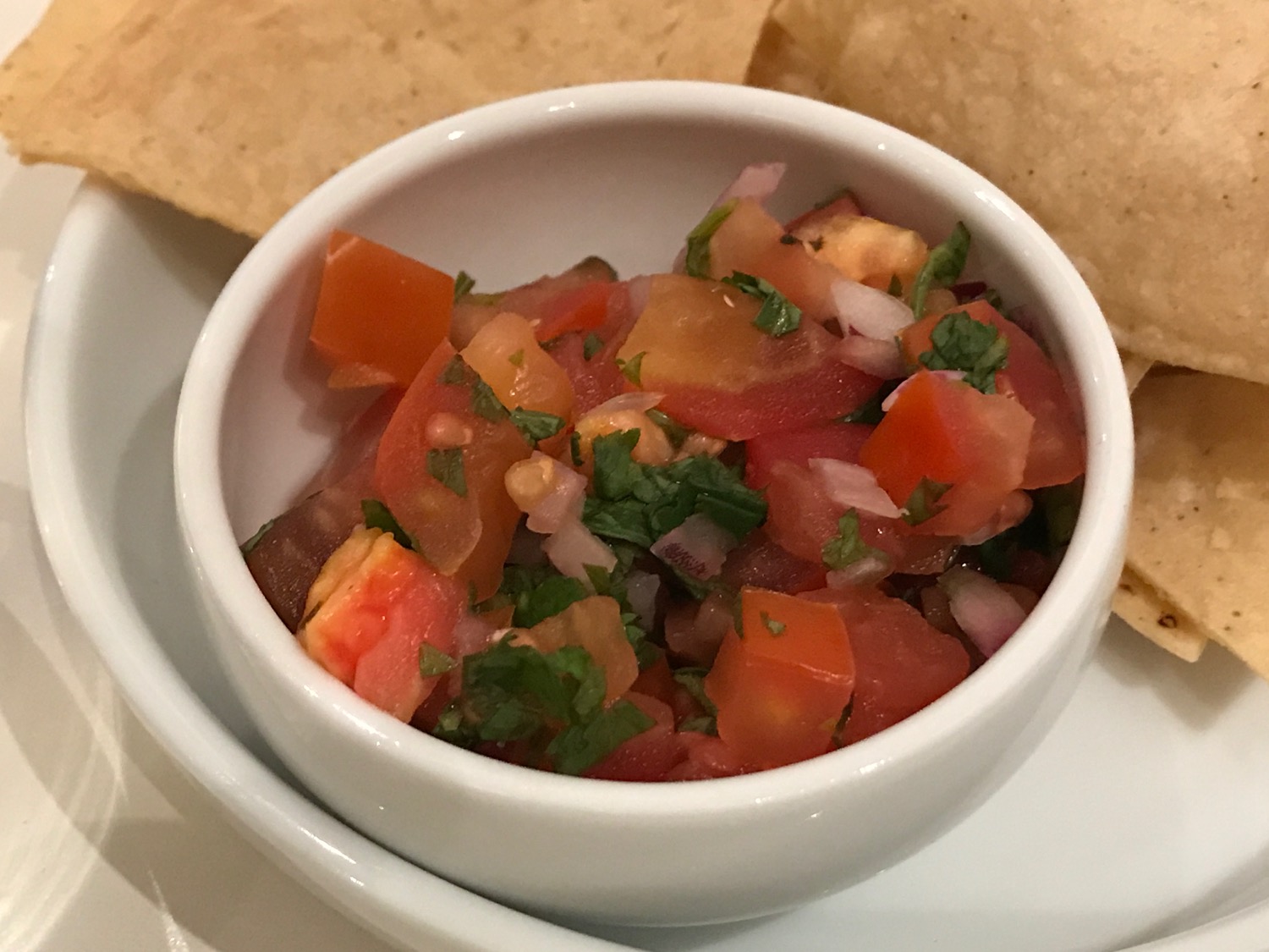 a bowl of salsa with chips