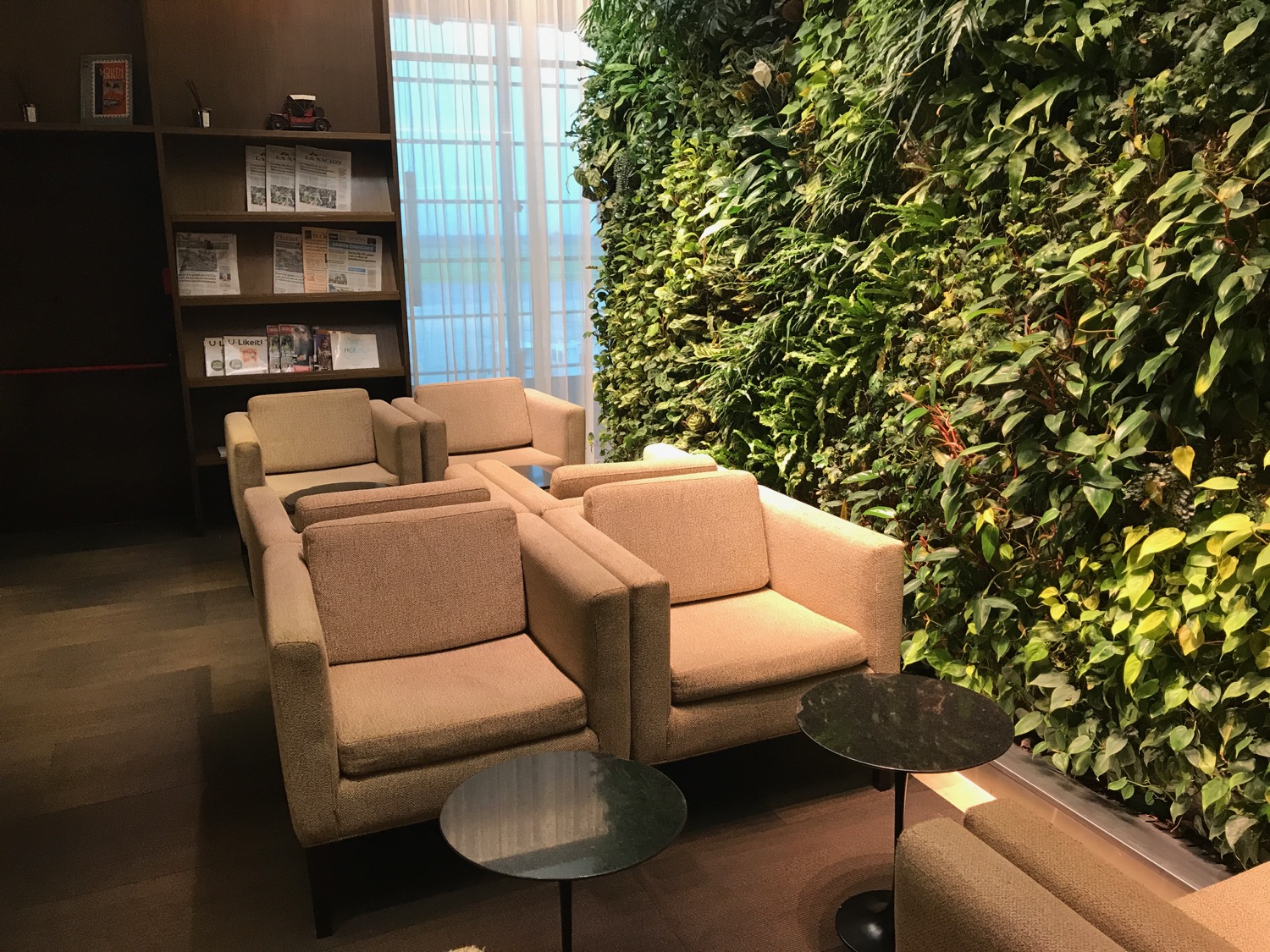 a room with chairs and a plant wall