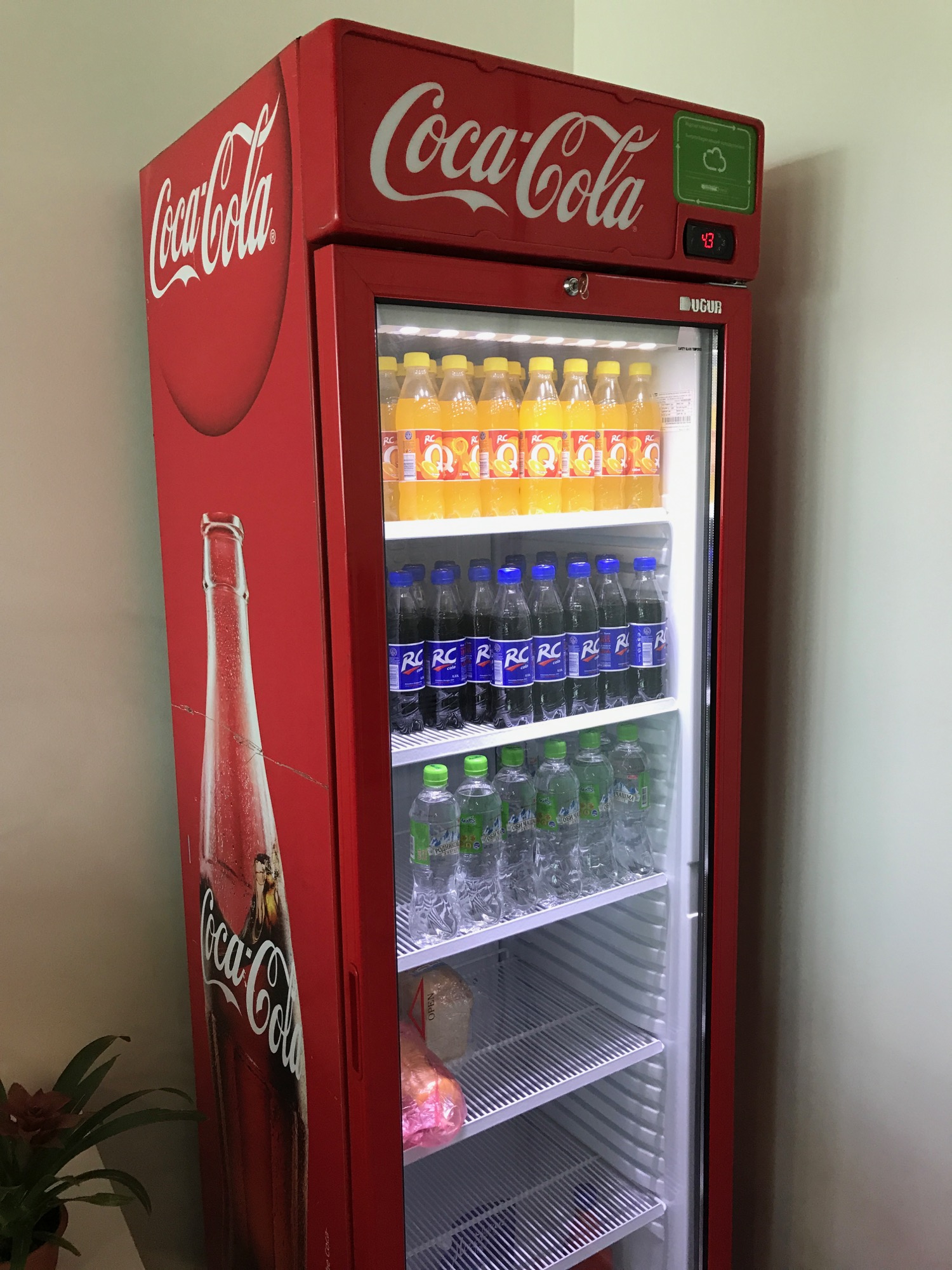 a red refrigerator with bottles of soda