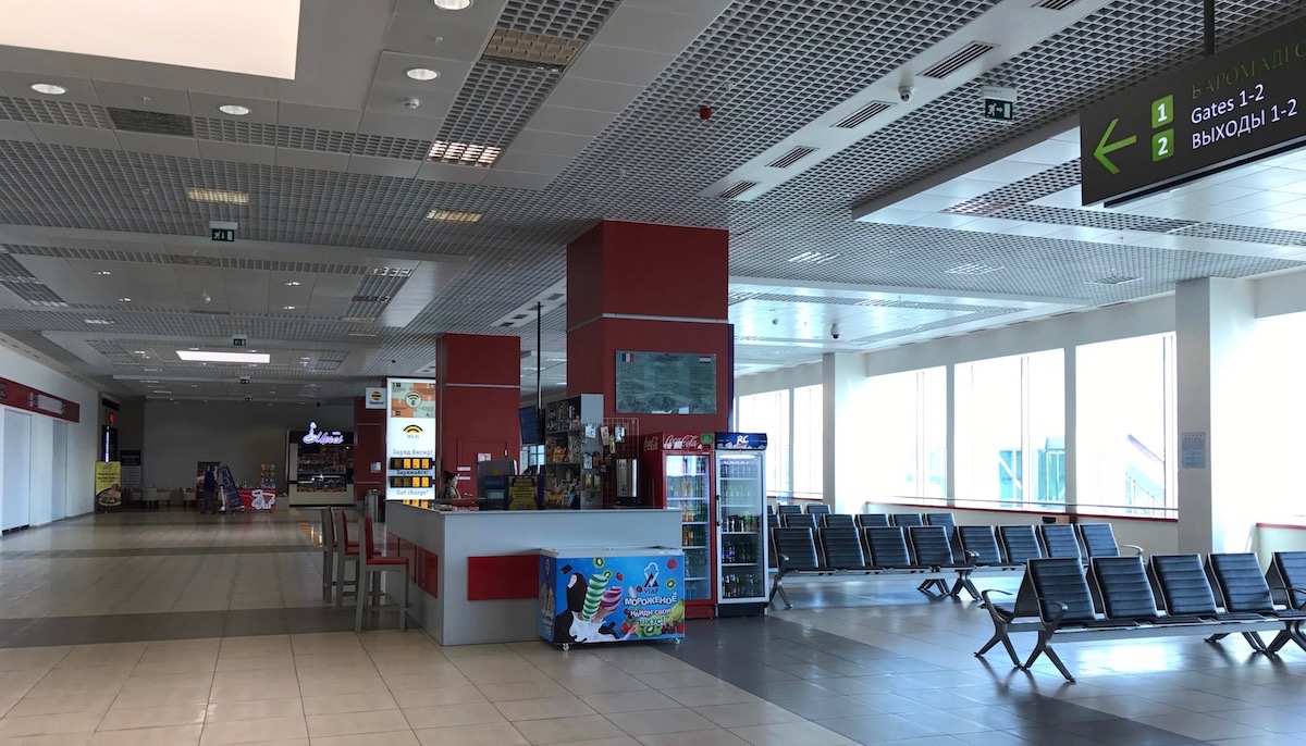 a large airport terminal with chairs and a counter