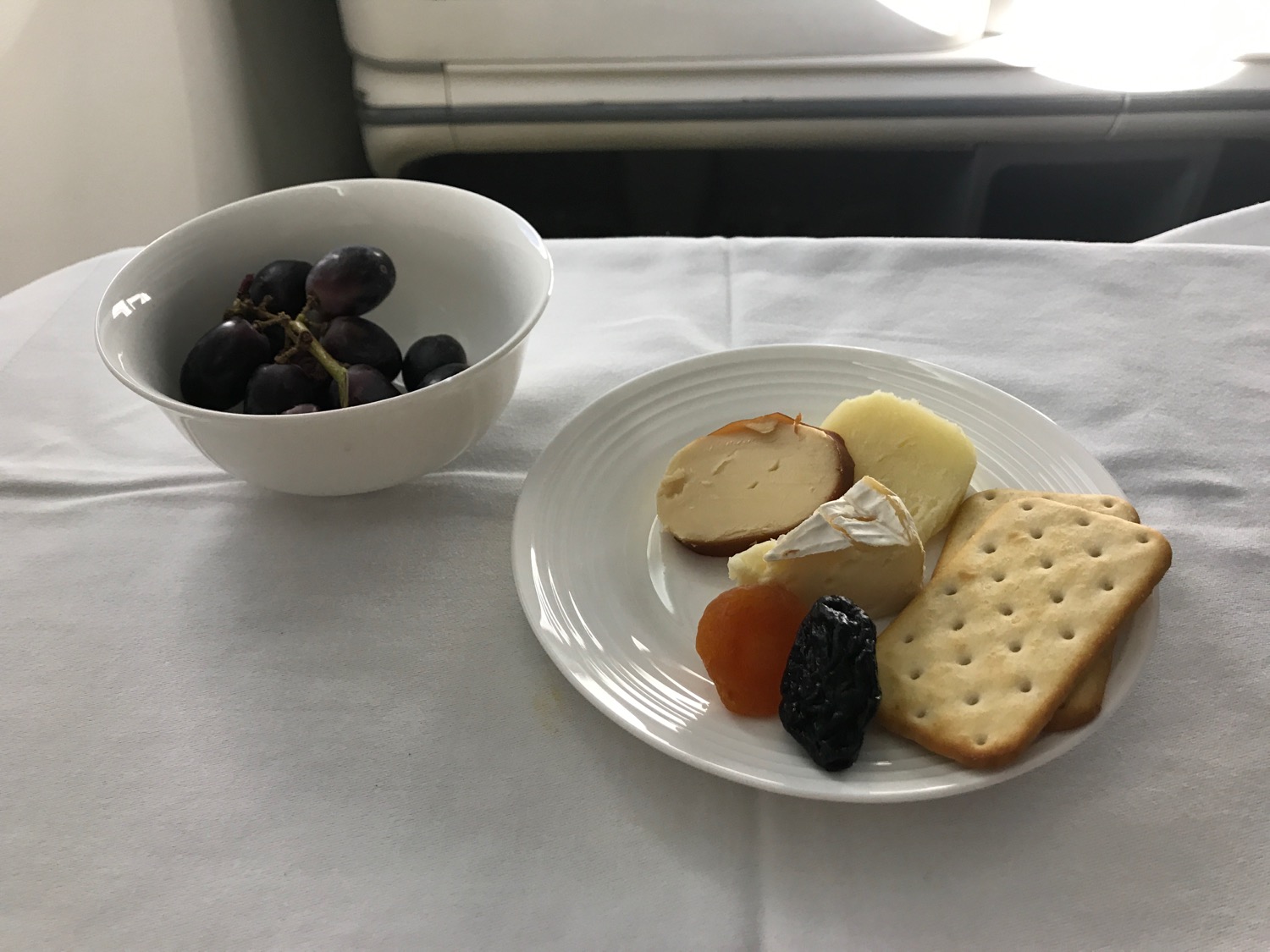 a plate of food and a bowl of grapes