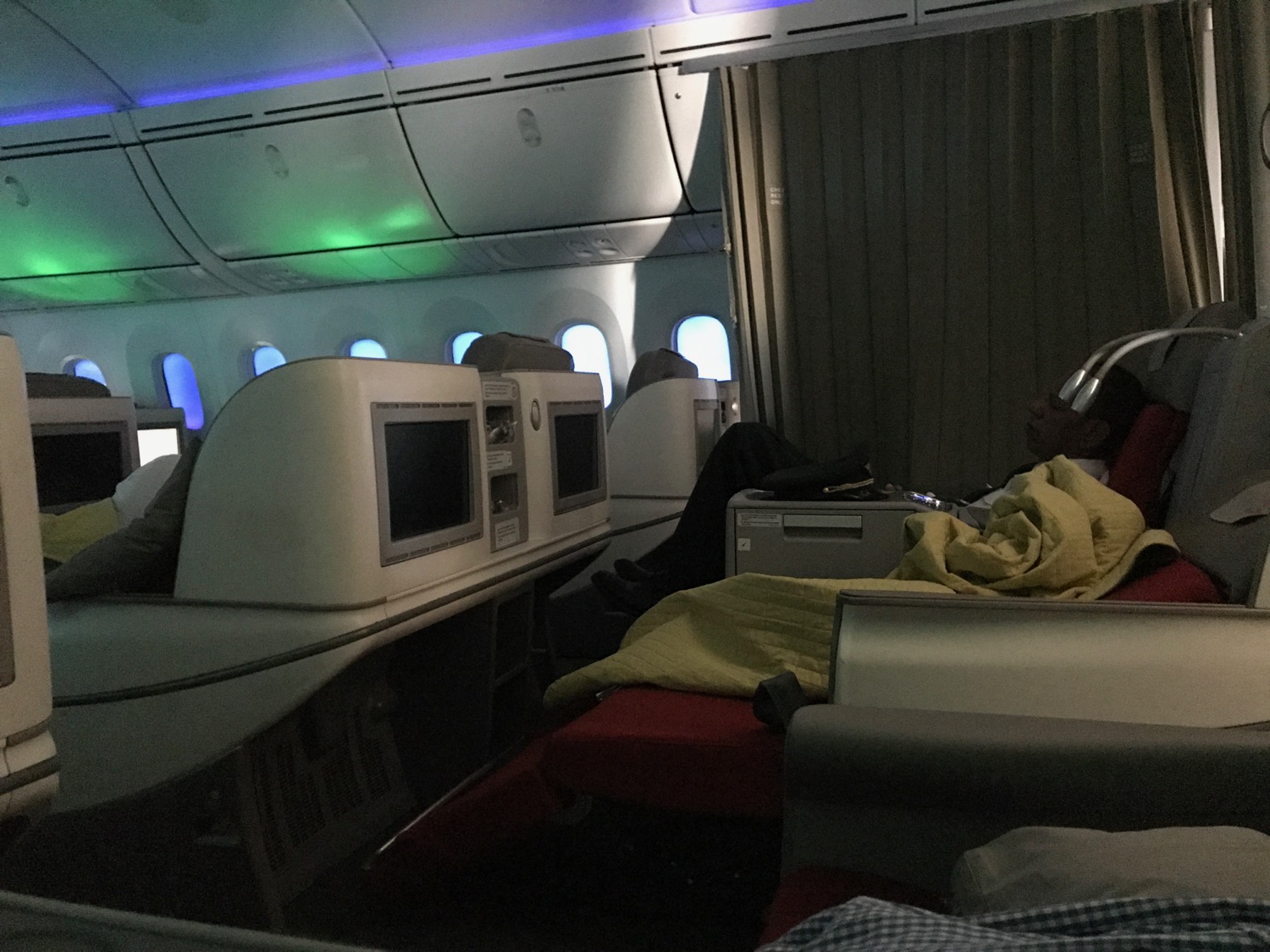 a person in a silver helmet on a bed in an airplane