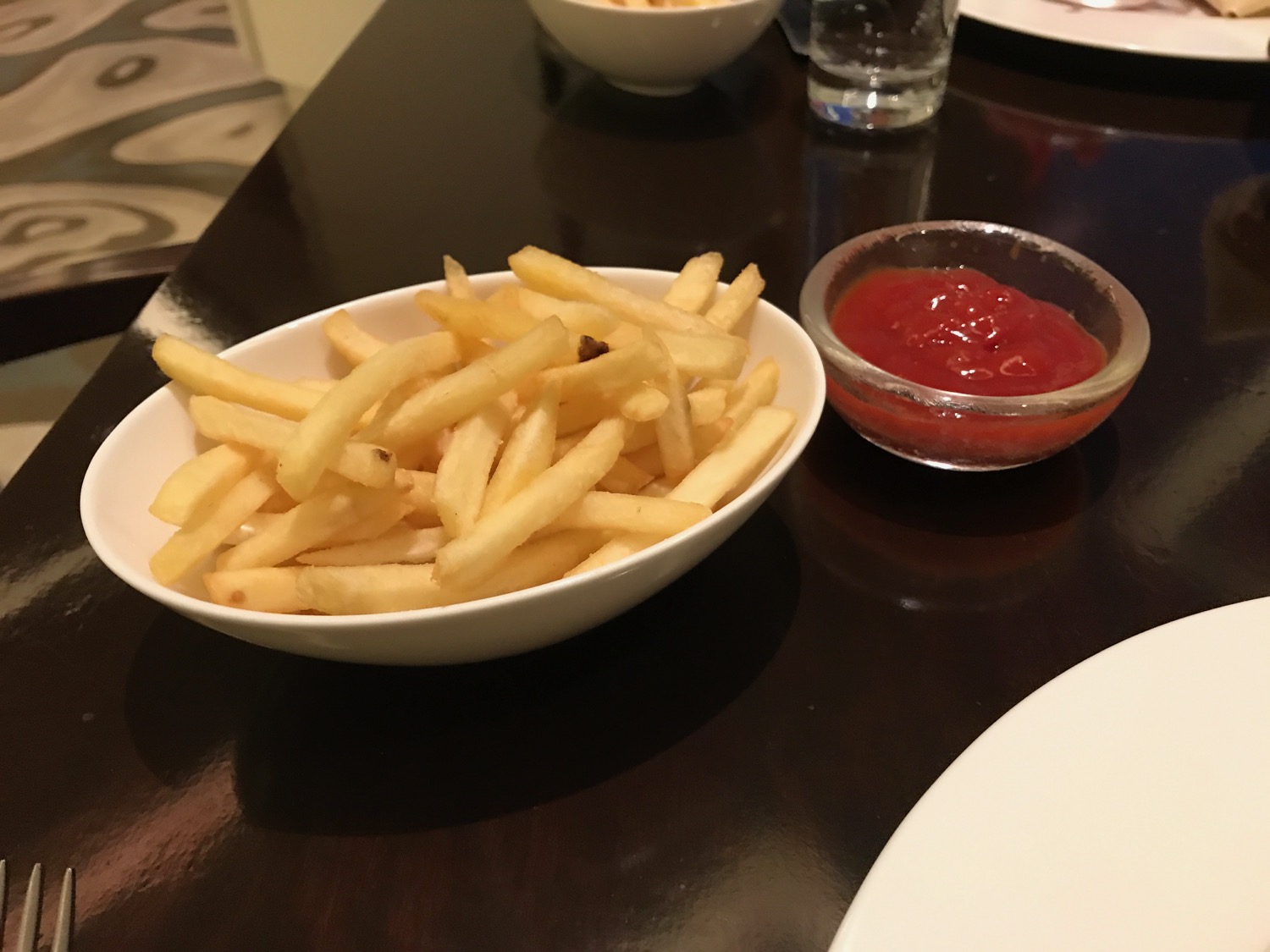 a bowl of french fries and ketchup on a table