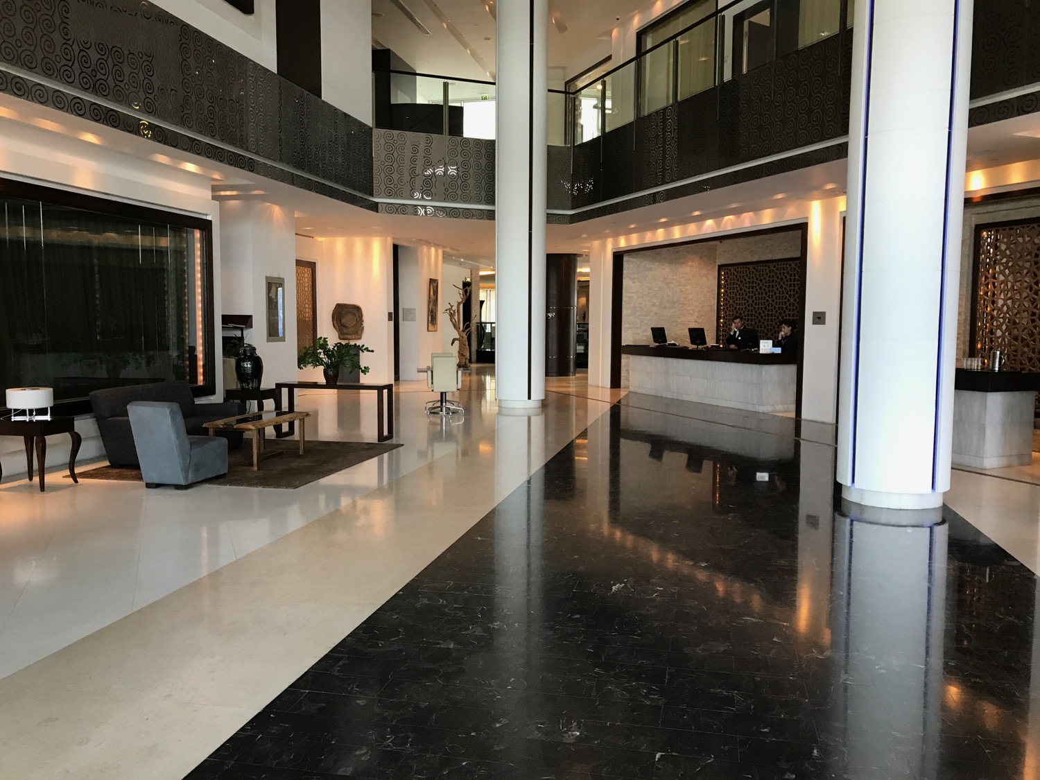 a lobby of a building with a black floor and a black and white floor