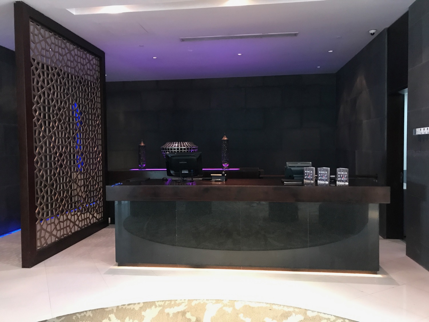 a black reception desk with purple lights