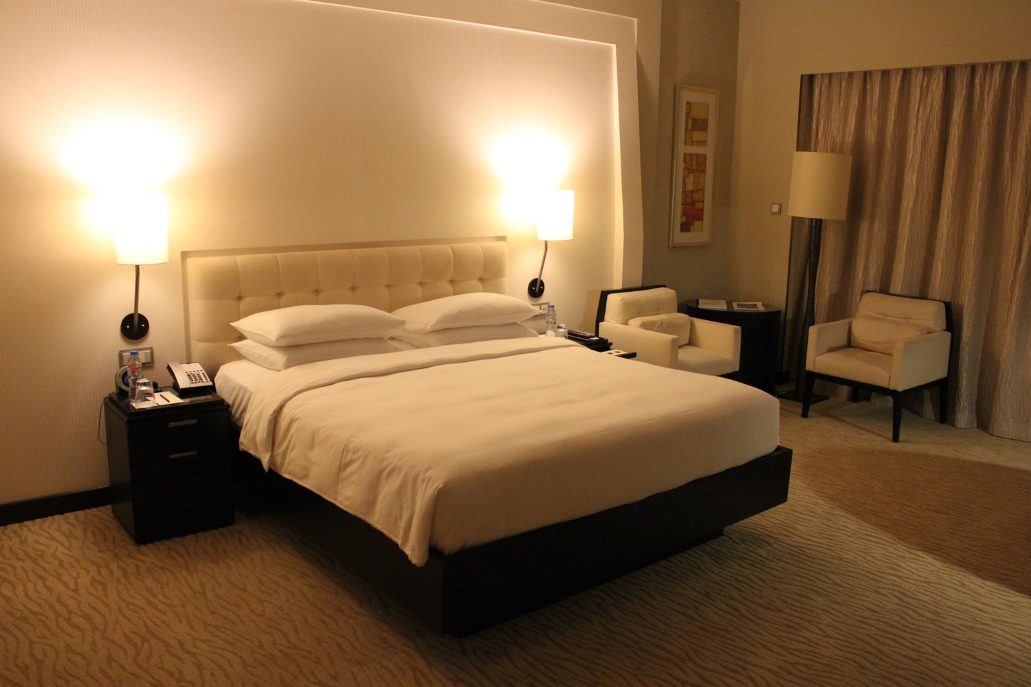 a bed with white sheets and a white headboard