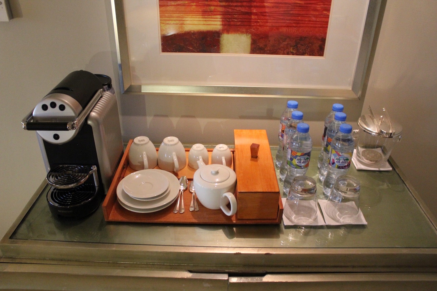 a tray of tea cups and water bottles on a counter
