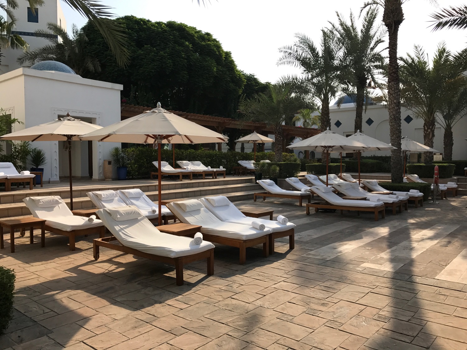 a group of lounge chairs and umbrellas outside